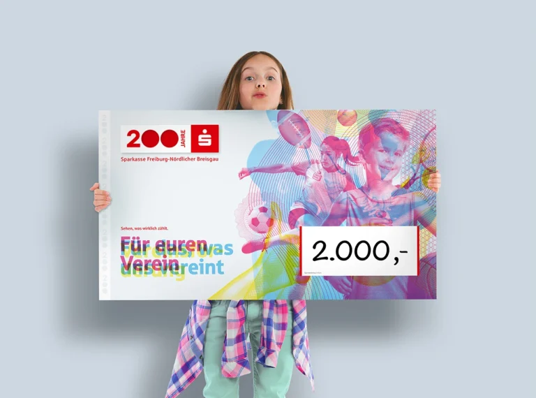 Person hält einen Scheck zur Jubi-Vereinsförderung der Sparkasse Freiburg-Nördlicher Breisgau mit einem Betrag von 2.000 Euro